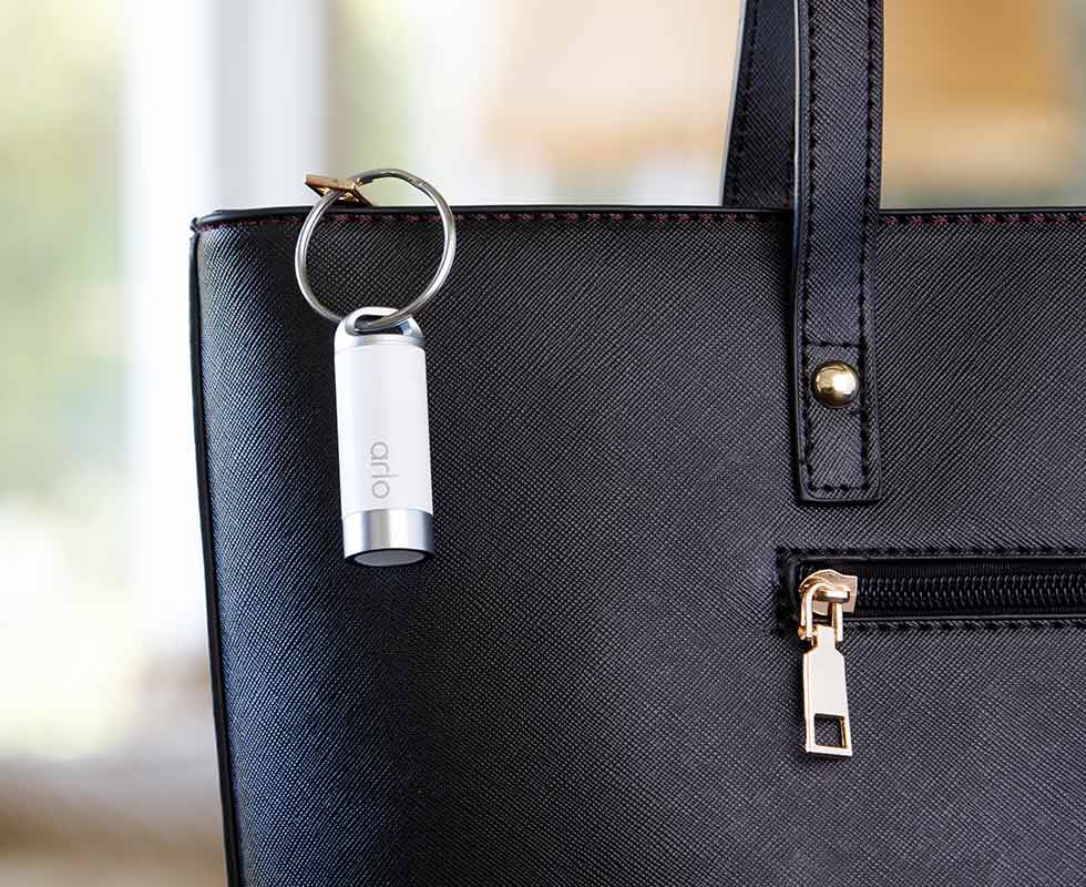 Arlo Safe button attached to a purse