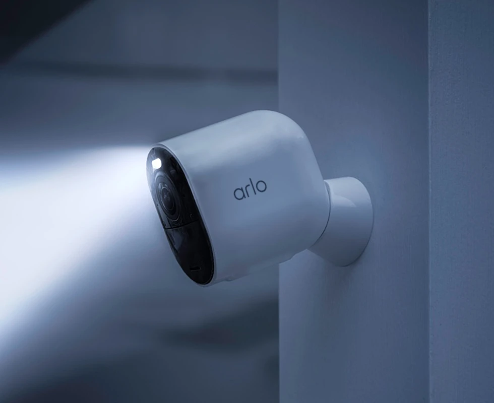 Arlo Ultra 2 attached to a wall with the spotlight activate at night