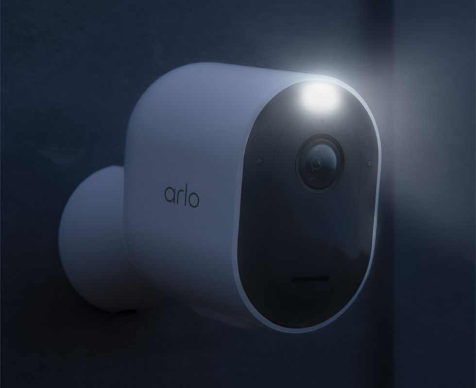 Arlo Pro 4 wireless security camera spotlight shining at night