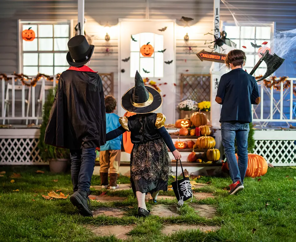 Kids trick-or-treating a Halloween decorated house.