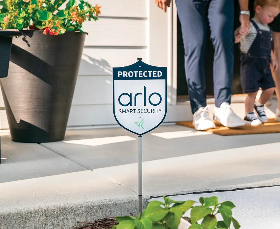 Protected Arlo security yard sign in the front yard of a house