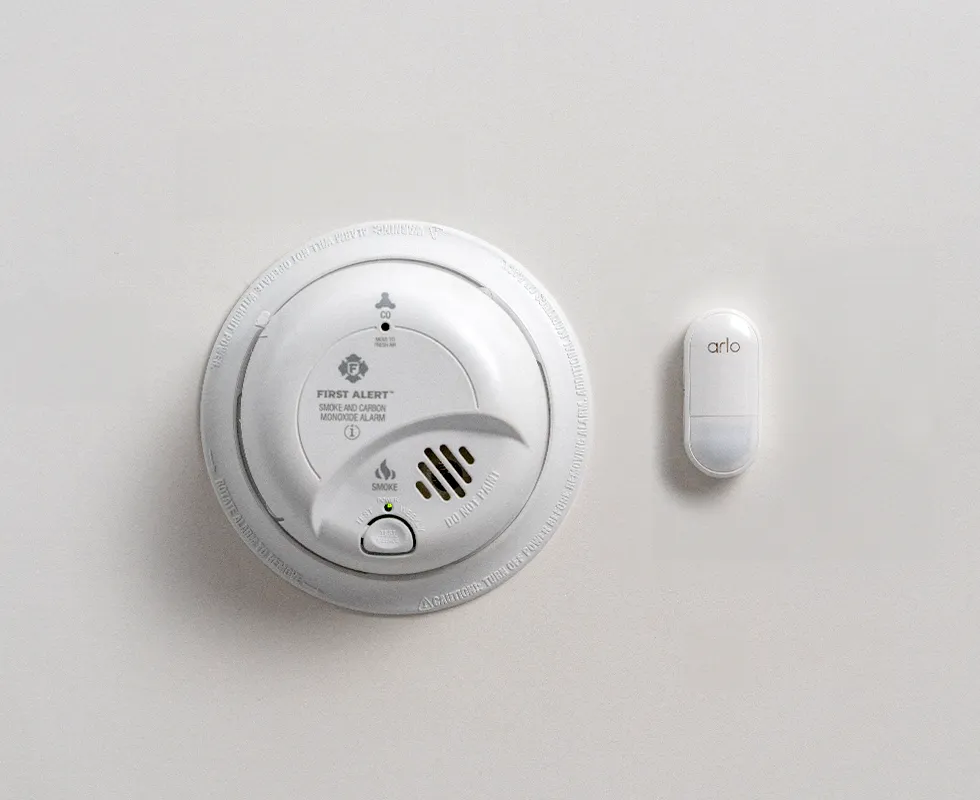 Smoke alarm next to an Arlo All-in-One sensor